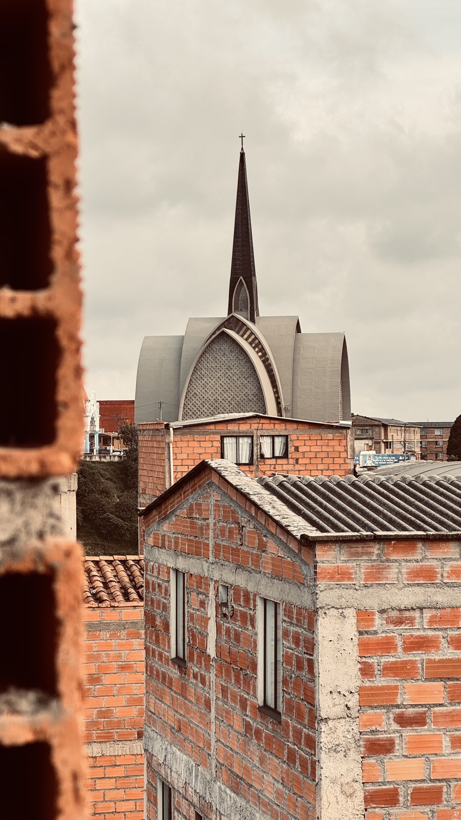 Rooftops of Barrio San Francisco run to the parish spire and the hills of Medellín.